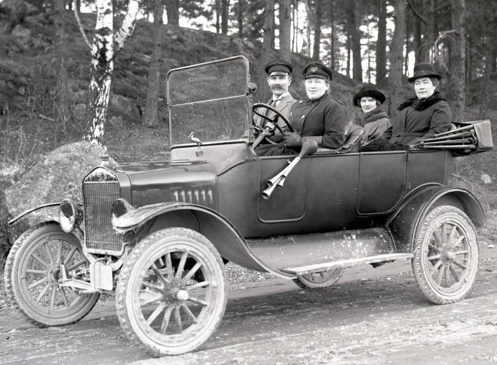 Hilda Pihlgren i förarsätet på sin bil tillsammans med Gustaf och Anna Ekstam samt Ellen Gunnarsson, 1923. Framför vindrutan hade hon en maskot i form av en stork. Foto: Emil Wijgård (1884-1974), Västerås stadsarkiv
