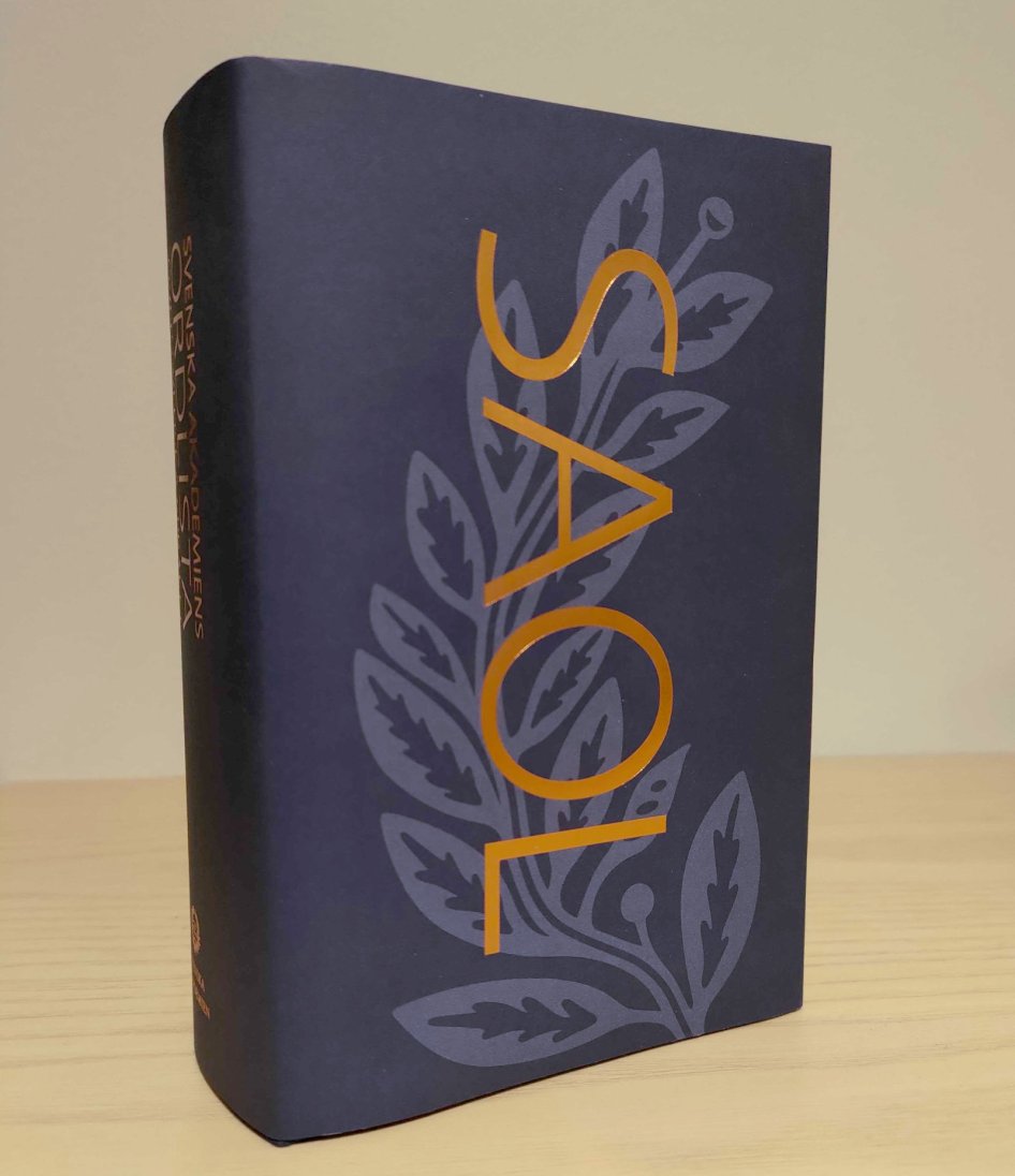 Boken SAOL15 står på ett bord.